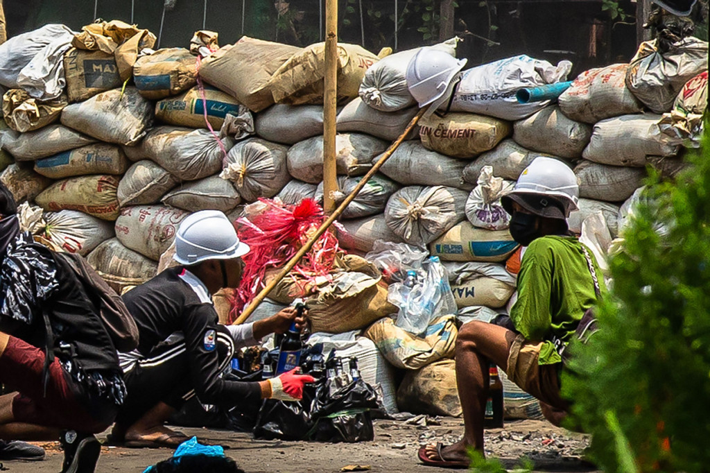 Sejumlah pengunjuk rasa menyiapkan bom molotov di jalan saat demonstrasi menentang kudeta militer di Kota Thaketa Yangon, Myanmar.