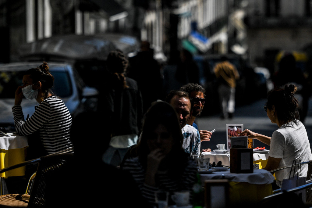 Orang-orang duduk dan bersantai di teras kafe di Lisbon saat pemerintah melonggarkan pembatasan virus korona, 5 April 2021.