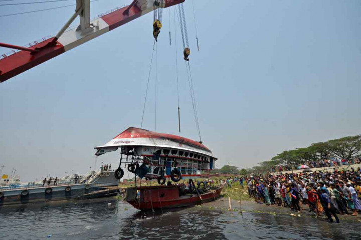 Petugas dibantu alat berat berhasil mengangkat kapal feri yang tenggelam di Sungai Shitalakhsya, selatan Ibu Kota Dhaka, Senin, 5 April 2021.