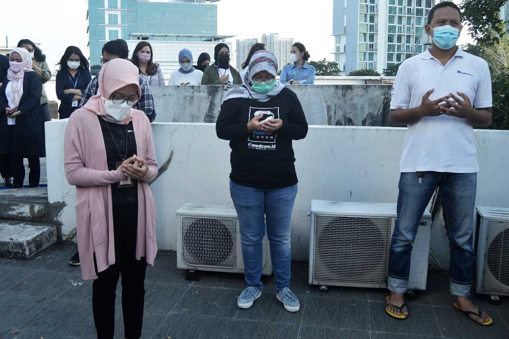 Karyawan khusuk berdoa saat pembukaan acara potluck di Rooftop lantai 4 gedung Medcom.id, Kedoya, Jakarta Barat.