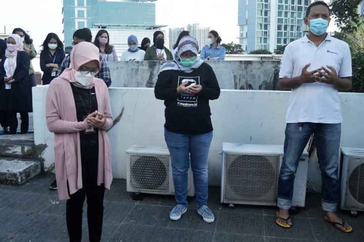 Karyawan khusuk berdoa saat pembukaan acara potluck di Rooftop lantai 4 gedung Medcom.id, Kedoya, Jakarta Barat.