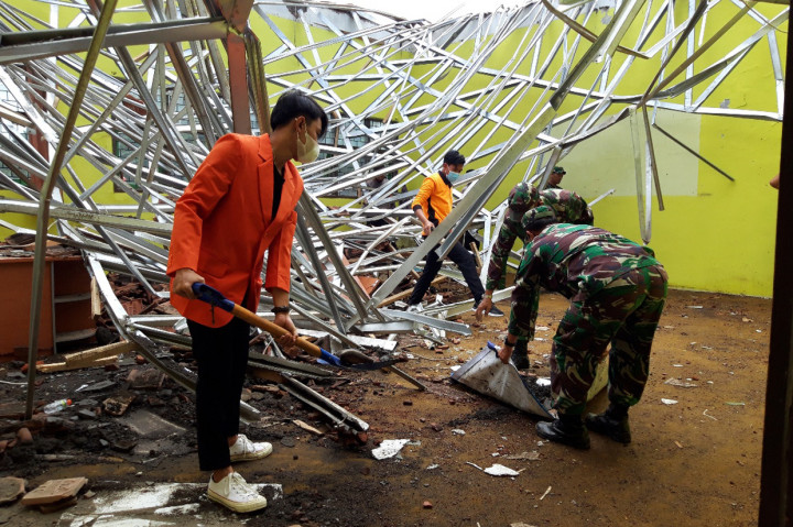 Petugas gabungan dan relawan membersihkan reruntuhan atap bangunan Madarasah Aliyah Negeri (MAN) 2 Turen, Kabupetan Malang, Jawa Timur, Minggu, 11 April 2021. Sebanyak 14 bangunan sekolahan rusak parah akibat gempa bumi 6,1 skala richter.