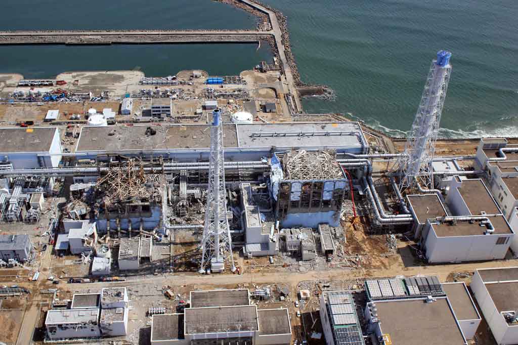 Gambar yang diambil pada 14 Februari 2021 menunjukkan pemandangan udara Pembangkit Listrik Tenaga Nuklir Fukushima Daiichi TEPCO (atas) yang sedang menjalani pekerjaan penonaktifan dan tangki (bawah) untuk menyimpan air olahan.