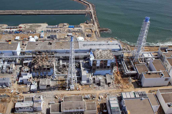 Gambar yang diambil pada 14 Februari 2021 menunjukkan pemandangan udara Pembangkit Listrik Tenaga Nuklir Fukushima Daiichi TEPCO (atas) yang sedang menjalani pekerjaan penonaktifan dan tangki (bawah) untuk menyimpan air olahan.
