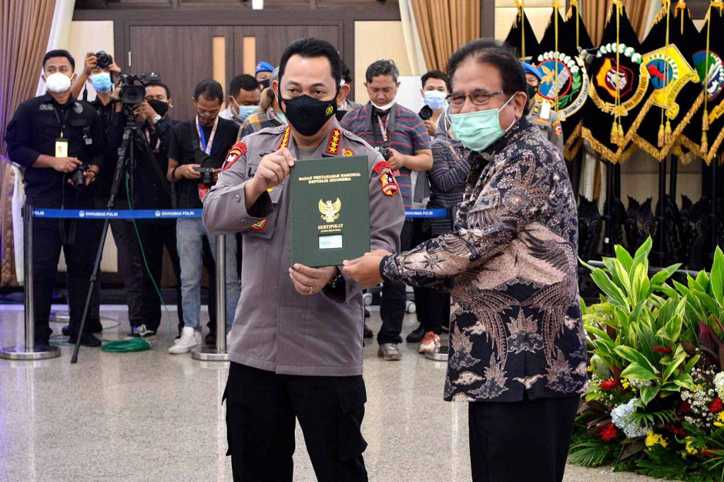 Menteri Agraria dan Tata Ruang/Kepala Badan Pertanahan Nasional Sofyan Djalil (kanan) menyerahkan sertifikat tanah kepada Kapolri Jenderal Pol Listyo Sigit Prabowo untuk pembangunan sarana Diklat Propam saat peluncuran aplikasi Proram Presisi di Mabes Polri, Jakarta.