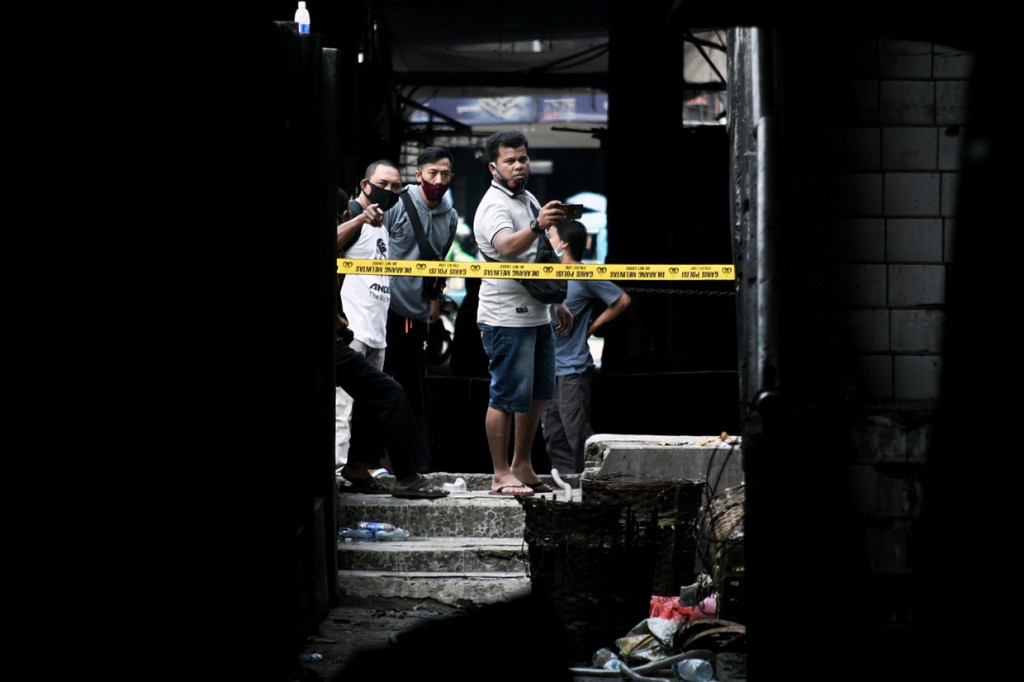 Sejumlah warga menyaksikan sisa kebakaran yang membakar Pasar Inpres Pasar Minggu, Jakarta Selatan, Selasa, 13 April 2021.