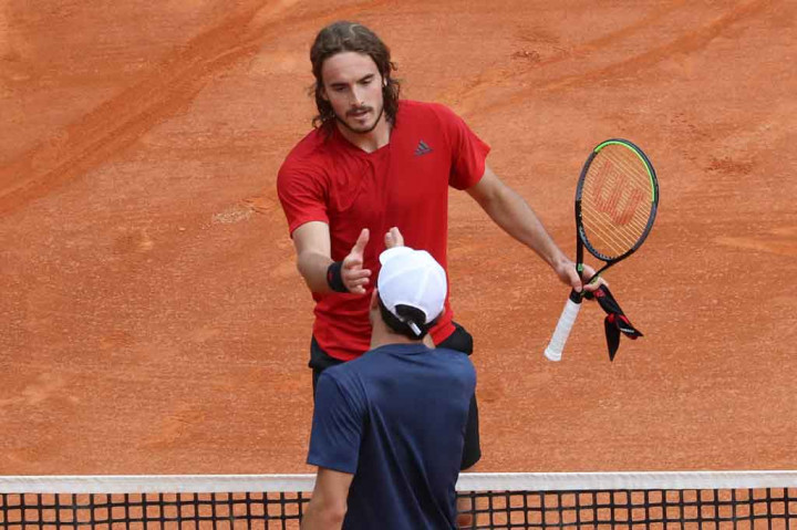 Stefanos Tsitsipas berjabat tangan dengan Aslan Karatsev dari Rusia usai memenangi pertandingan putaran kedua turnamen tenis Monte-Carlo ATP 1000 Masters Series di Monte-Carlo, Monaco pada Selasa, 13 April 2021 waktu setempat.