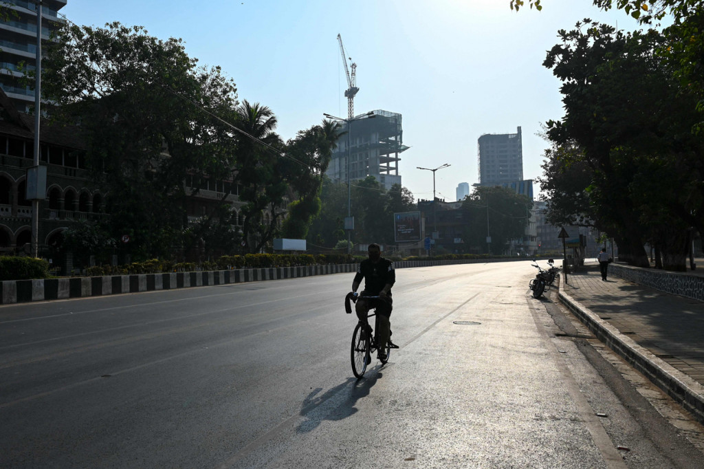 Seorang pengendara sepeda melintas di jalan sepi selama pembatasan yang diberlakukan pemerintah negara bagian di tengah meningkatnya kasus Covid-19 di Mumbai.