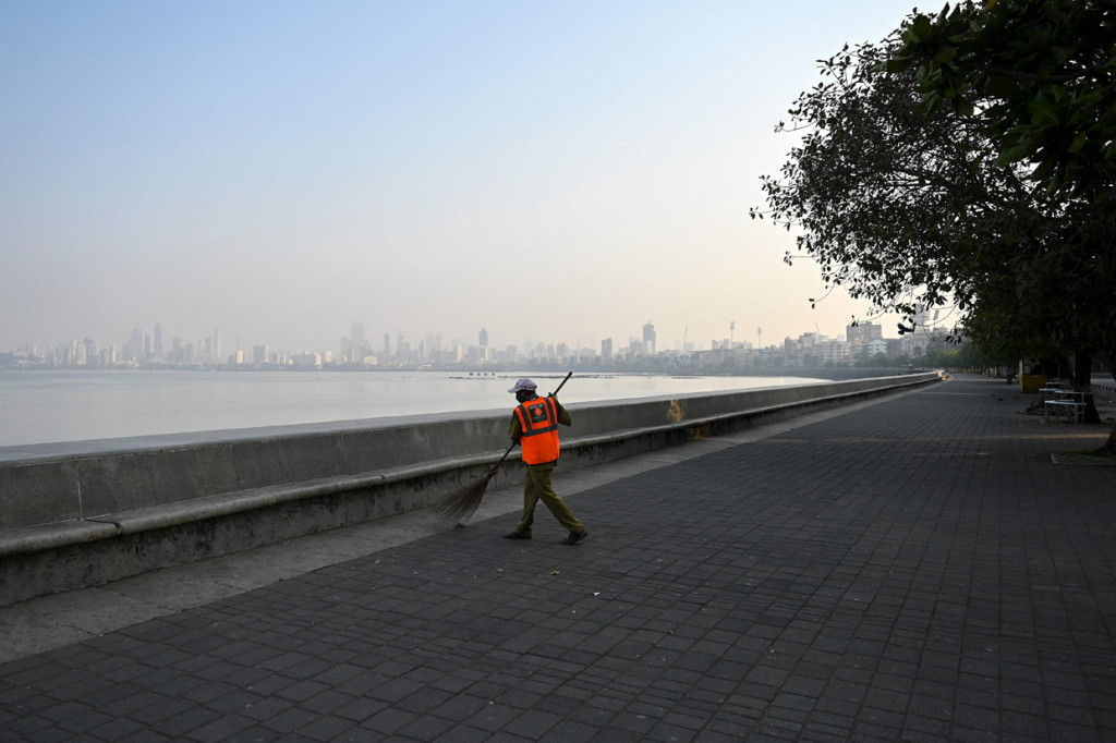 Pekerja otoritas sipil membersihkan daerah terpencil di dekat tepi laut selama pembatasan yang diberlakukan oleh pemerintah negara bagian di tengah meningkatnya kasus Covid-19, di Mumbai.