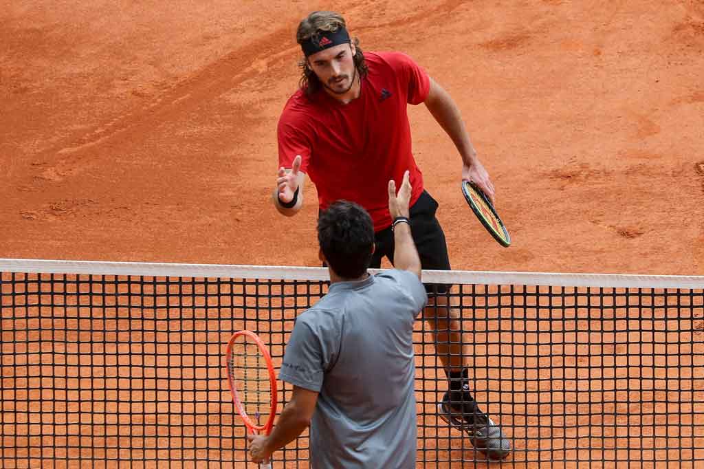 Stefanos Tsitsipas (atas) dari Yunani berjabat tangan dengan Christian Garin dari Chili usai memenangi pertandingan putaran ketiga turnamen Monte-Carlo ATP Masters Series di Monaco pada Kamis, 15 April 2021.