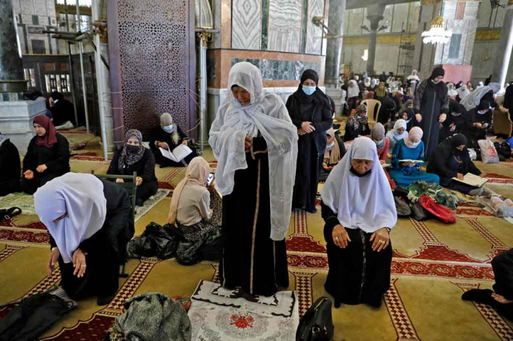 
Menjelang sore, perempuan Palestina berjilbab dan jubah panjang duduk di lantai berkarpet kompleks masjid Al-Aqsa sambil membaca kitab suci Alquran.