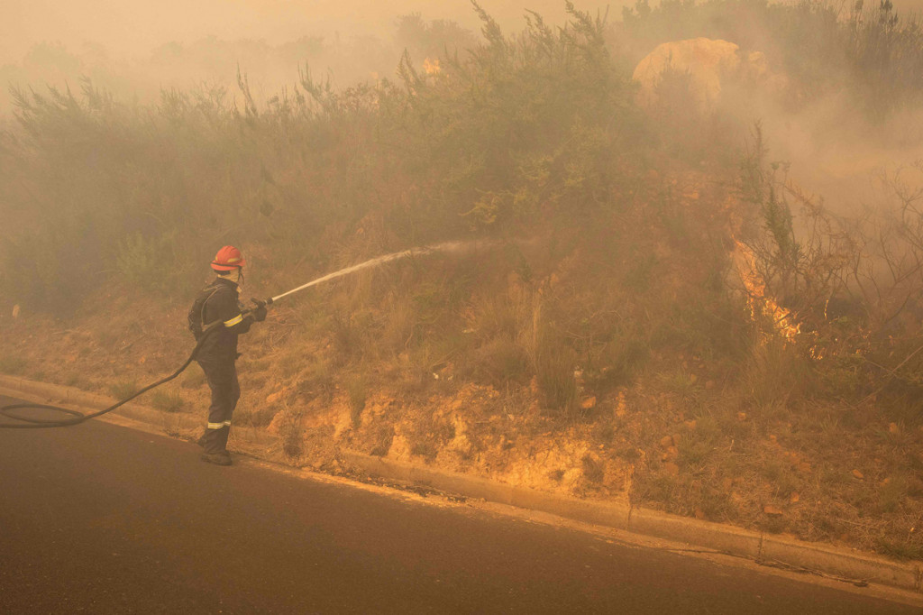 Embusan angin di wilayah cekungan Gunung Meja membuat kobaran api semakin besar akibat semak belukar ikut terbakar.