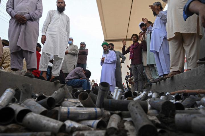 Pendukung partai Tehrik-e-Labaik Pakistan (TLP) berkumpul di sekitar peluru gas air mata kosong yang ditembakkan oleh polisi ketika mereka memblokir jalan selama protes setelah pemimpin mereka ditahan menyusul seruannya untuk pengusiran duta besar Prancis, di Lahore.