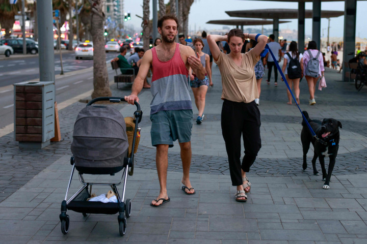 Orang-orang menikmati udara kebebasan tanpa masker di dekat pantai di kota Tel Aviv, Israel, setelah pihak berwenang mengumumkan bahwa masker wajah untuk pencegahan Covid-19 tidak lagi diperlukan di luar.