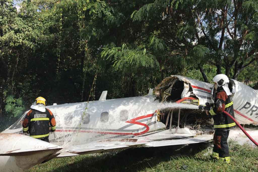 Petugas melakukan pembasahan terhadap pesawat5 yang tergelincir saat prosedur pendaratan di bandara Pampulha, di Belo Horizonte, negara bagian Minas Gerais, Brasil, pada Selasa, 20 April 2021.