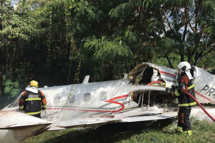 Petugas melakukan pembasahan terhadap pesawat5 yang tergelincir saat prosedur pendaratan di bandara Pampulha, di Belo Horizonte, negara bagian Minas Gerais, Brasil, pada Selasa, 20 April 2021.