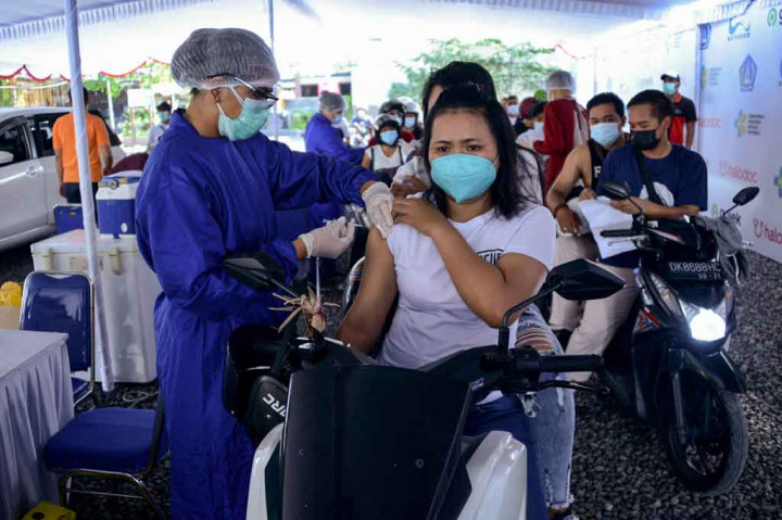 Vaksinator menyuntikkan vaksin COVID-19 kepada warga yang berada di atas kendaraan pada pelaksanaan vaksinasi covid-19 dengan sistem 'drive thru' di Kuta, Badung, Bali, Rabu, 21 April 2021.