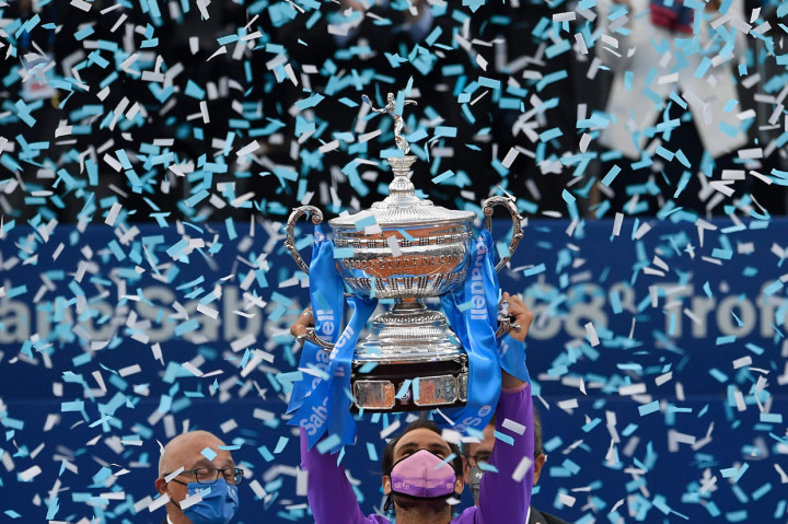 afael Nadal sukses menuntaskan dendam ke Stefanos Tsitsipas. Nadal mengalahkan petenis Yunani itu dengan skor 6-4, 6-7 (6/8), 7-5 untuk mengamankan titel juara Barcelona Open.