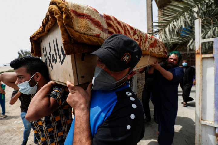 Warga Irak mengangkut peti mati kerabat yang tewas dalam kebakaran di rumah sakit Ibn al-Khatib yang disediakan untuk kasus Covid-19 paling parah, di ibu kota Baghdad.