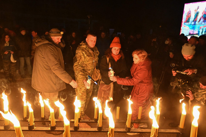 Orang-orang menyalakan lilin di alun-alun kota hantu Pripyat, Ukraina, dekat Pembangkit Listrik Tenaga Nuklir Chernobyl Senin, 26 April 2021.