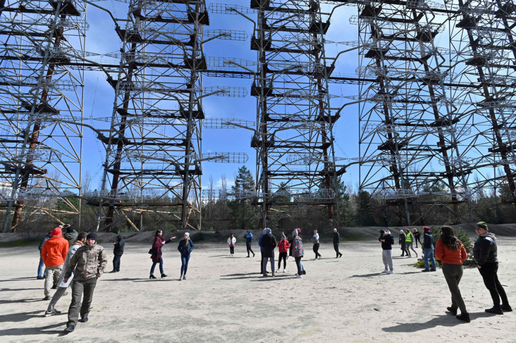 Orang-orang berdiri menyaksikan bagian dari sisa sistem radar Duga-1 yang tidak terpakai yang dibangun Soviet di dekat Chernobyl, Ukraina, Sabtu, 24 April 2021. Peringatan ke-35 dari bencana nuklir terburuk di dunia akan diperingati di negara eks Soviet ini pada 26 April 2021.