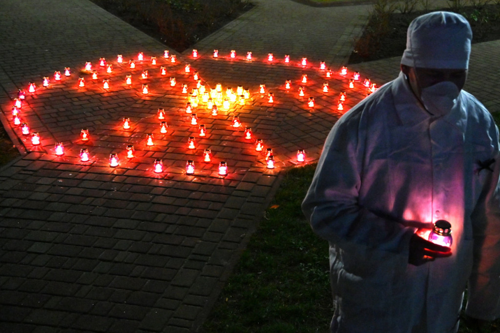 Karyawan pabrik Chernobyl membawa lilin di dekat tanda radioaktif pada upacara peringatan tragedi Chernobyl di monumen korban Chernobyl di Slavutych, Ukraina.