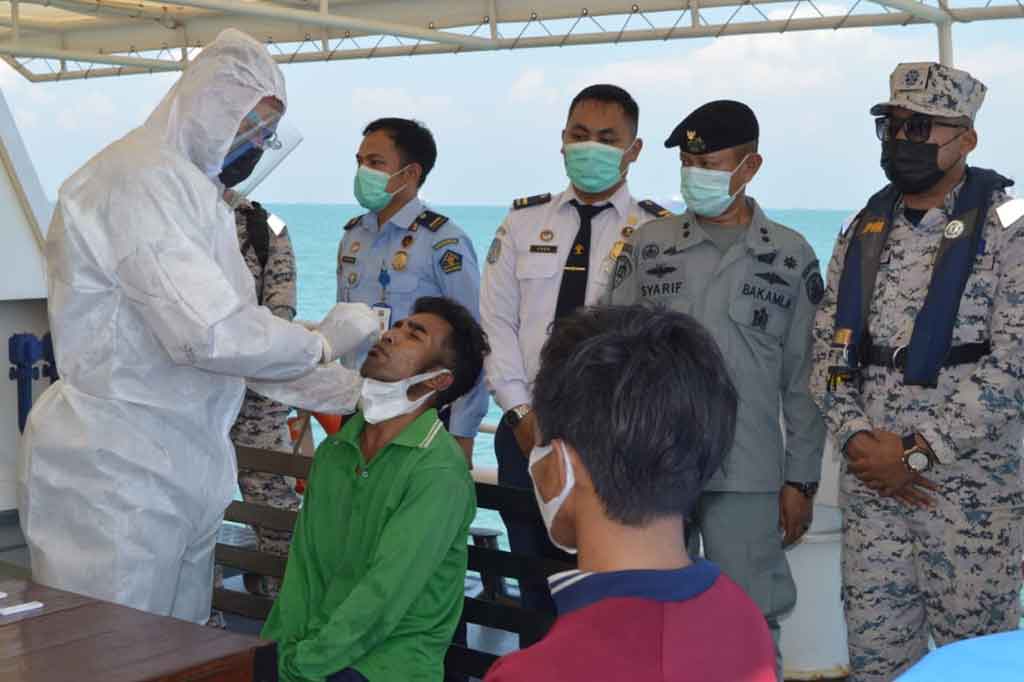 Anggota Badan Keamanan Laut (Bakamla) melakukan pengecekan kesehatan dua orang nelayan asal Batam saat berada diatas kapal Bakamla RI KN Bintang laut-401 di perairan Malaysia.