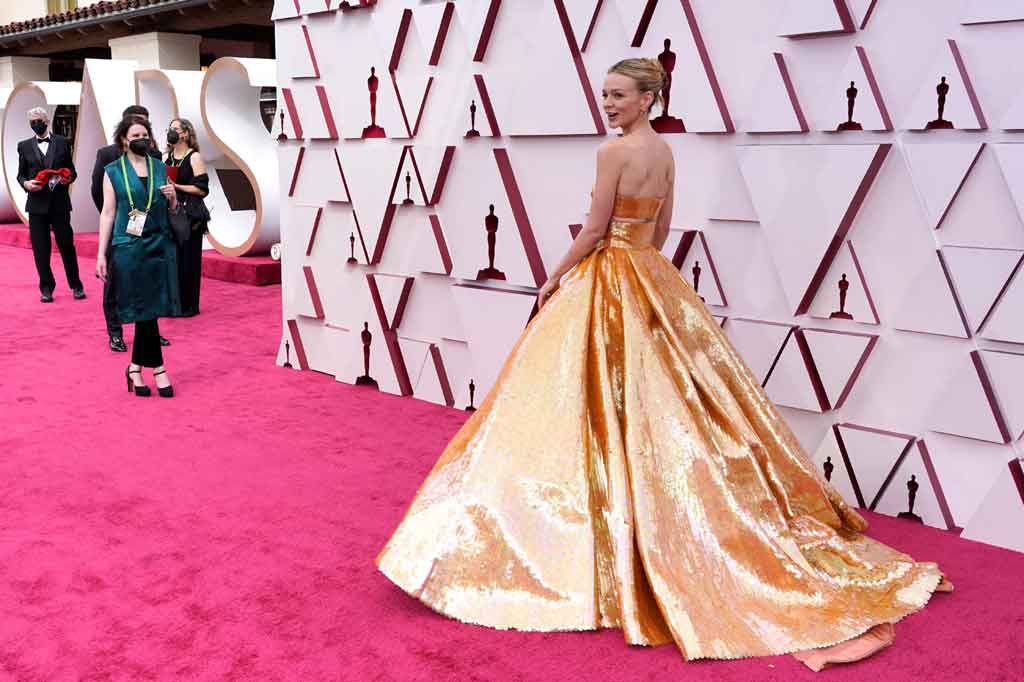 
Setelan jas yang dikenakan Odom Jr tersebut sejalan dengan tema emas yang terlihat di karpet merah, seperti Carey Mulligan yang mengenakan gaun emas dari Valentino dan pada Andra Day dengan gaun potongan Vera Wang metalik emas kustom.