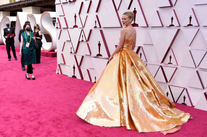 
Setelan jas yang dikenakan Odom Jr tersebut sejalan dengan tema emas yang terlihat di karpet merah, seperti Carey Mulligan yang mengenakan gaun emas dari Valentino dan pada Andra Day dengan gaun potongan Vera Wang metalik emas kustom.