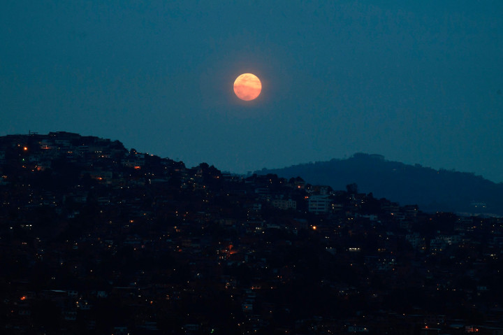 Bulan Purnama Super Pink terlihat di atas lingkungan Petare di Caracas, Venezuela. AFP Photo/Federico Parra