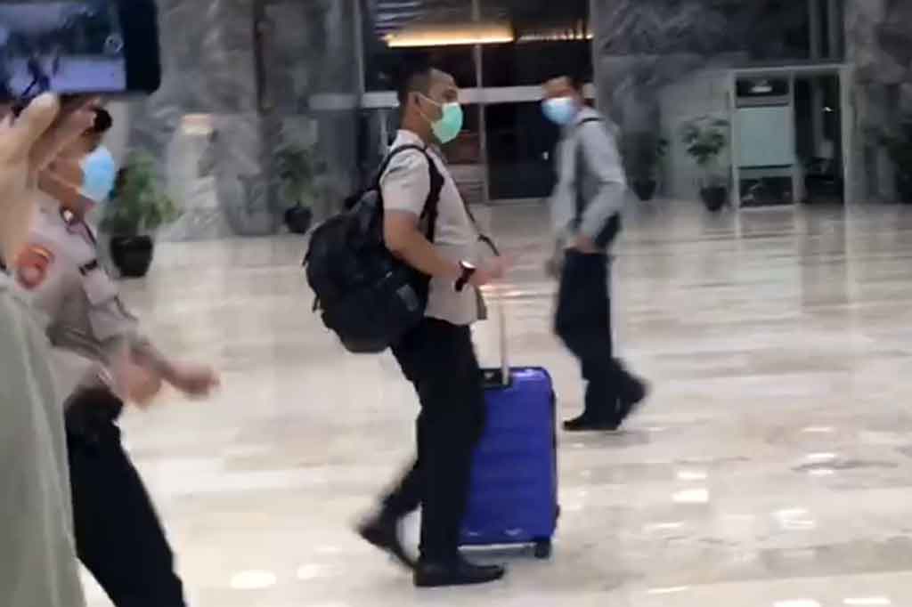 Salah satu penyidik turun membawa koper berwarna biru. Berselang 10 menit kemudian, penyidik kembali turun membawa koper didampingi personel kepolisian.