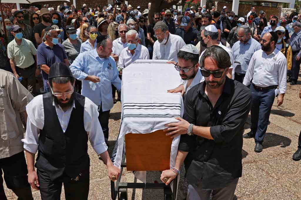 Kerabat dan teman membawa peti mati perancang busana Israel-Prancis terkenal Alber Elbaz selama pemakamannya di kota Holon Israel dekat Tel Aviv, pada 28 April 2021. Elbaz meninggal pada akhir pekan lalu di Paris pada usia 59 tahun setelah pertempuran dengan covid-19.