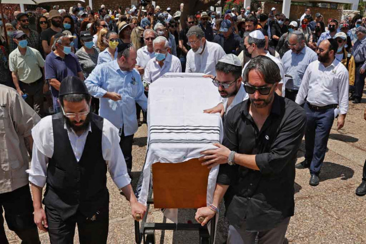 Kerabat dan teman membawa peti mati perancang busana Israel-Prancis terkenal Alber Elbaz selama pemakamannya di kota Holon Israel dekat Tel Aviv, pada 28 April 2021. Elbaz meninggal pada akhir pekan lalu di Paris pada usia 59 tahun setelah pertempuran dengan covid-19.