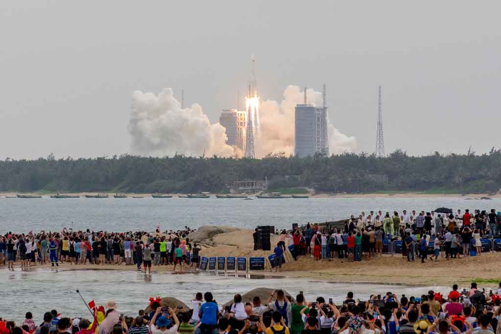 Warga menonton roket Long March 5B, yang membawa modul inti stasiun luar angkasa Tianhe Tiongkok, lepas landas dari Pusat Peluncuran Luar Angkasa Wenchang, di Provinsi Hainan, Tiongkok selatan pada Kamis, 29 April 2021.