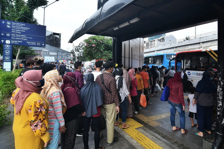 Warga mengantre menaiki bus Transjakarta di Halte Jaklinko, Tanah Abang, Jakarta.
