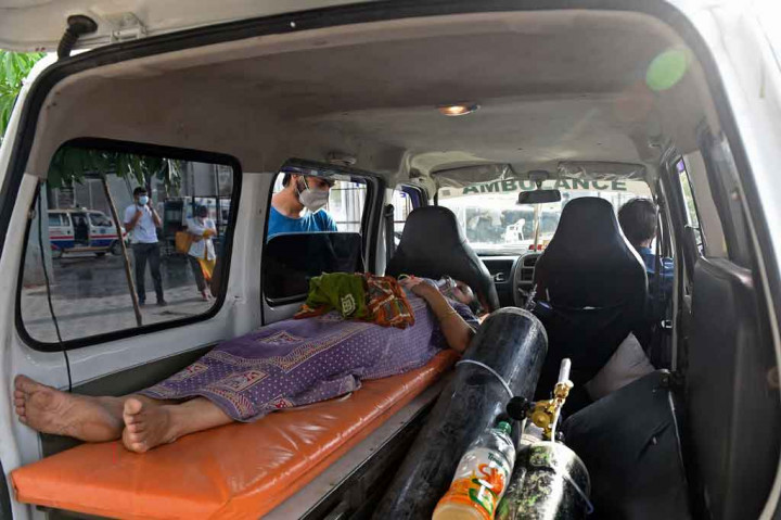 Seorang pasien virus corona (Covid-19) terbaring di dalam ambulans sambil menunggu masuk di rumah sakit sipil di Ahmedabad, India pada Senin, 3 Mei 2021.