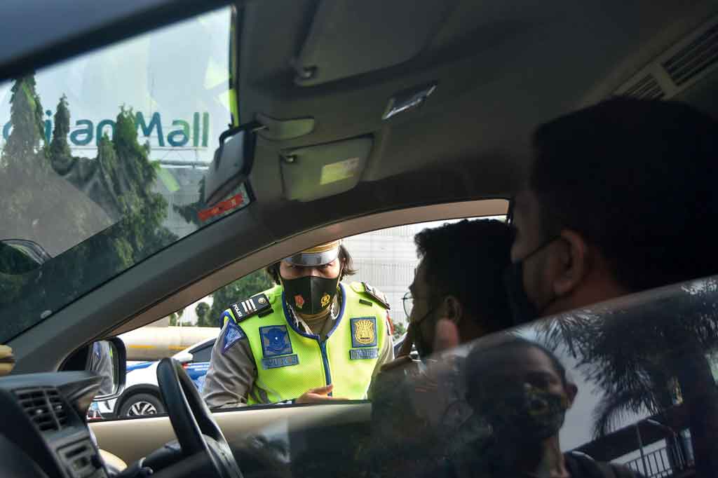 Petugas Kepolisian memeriksa dokumen pengendara yang melintas di salah satu check point penyekatan arus mudik di Bekasi, Jawa Barat, Kamis, 6 Mei 2021. 