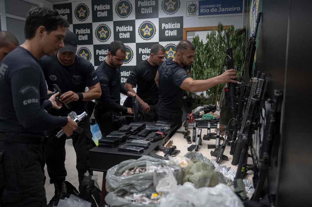 Petugas memperlihatkan obat-obatan terlarang dan senajta yang berhasil disita selama operasi penggerebekan terhadap tersangka pengedar narkoba di Jacarezinho.