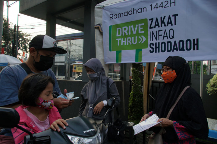 Warga yang membayar zakat dengan menggunakan kendaraan bermotor dilayani para petugas amil Zakat tanpa harus turun dari kendaraan mereka.