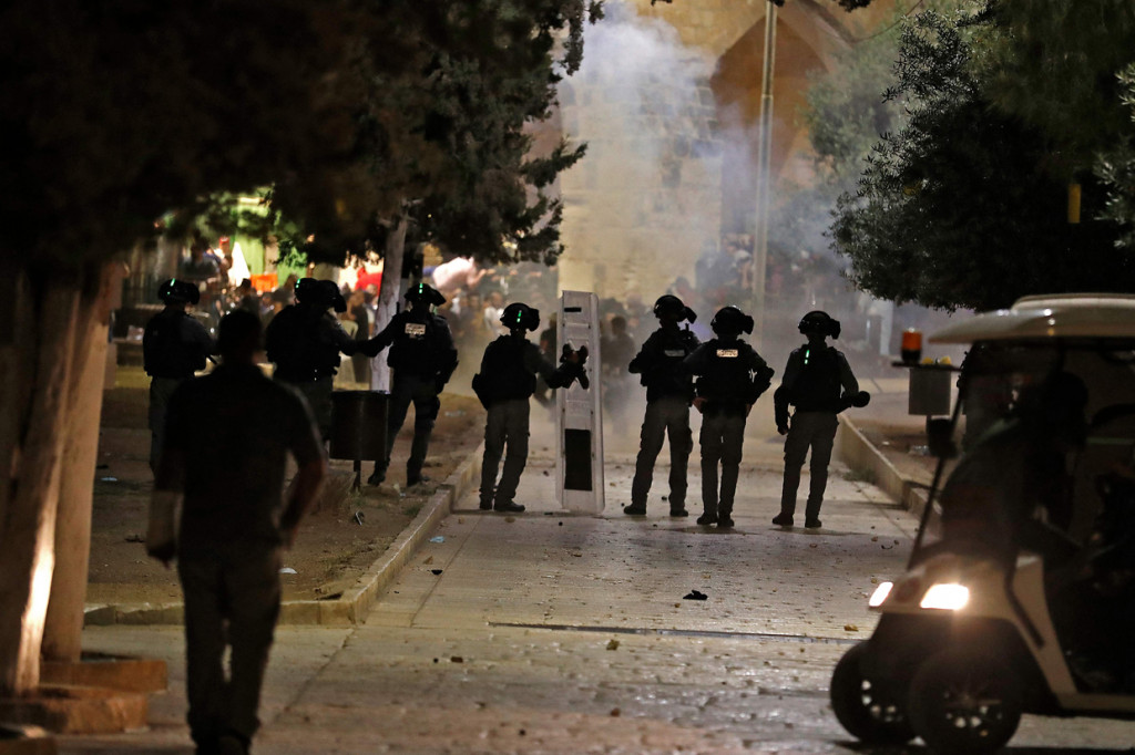 Asap mengepul di depan masjid dan kuil berkubah emas yang ikonik di kompleks suci tersebut pada Senin, 10 Mei 2021, waktu setempat.