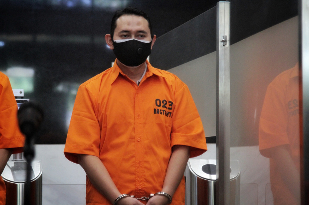 Novi Rahman tampak memakai oranye atau baju tahanan dengan tangan diborgol.