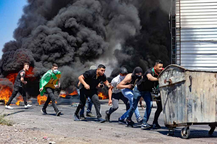 Para pemuda Palestina terlibat bentrokan dengan pasukan keamanan Israel di dekat pos pemeriksaan Hawara, selatan Kota Nablus, Tepi Barat, Jumat, 14 Mei 2021.