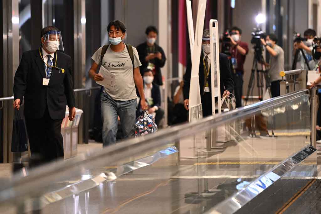 Wartawan Jepang Yuki Kitazumi (kedua kiri), yang ditangkap oleh pasukan keamanan Myanmar saat meliput pascakudeta Myanmar, tiba di Bandara Narita di Narita, Prefektur Chiba pada Jumat, 14 Mei 2021. Wartawan tersebut dideportasi setelah dakwaan terhadapnya dicabut sebagai isyarat diplomatik.