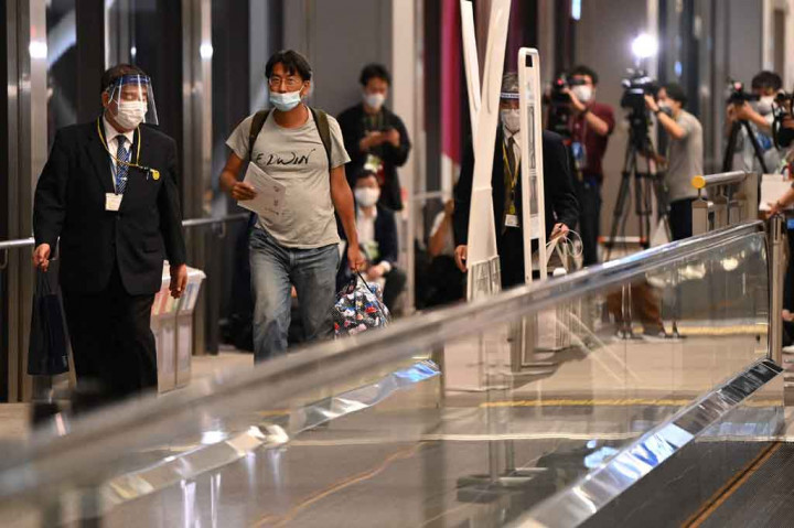 Wartawan Jepang Yuki Kitazumi (kedua kiri), yang ditangkap oleh pasukan keamanan Myanmar saat meliput pascakudeta Myanmar, tiba di Bandara Narita di Narita, Prefektur Chiba pada Jumat, 14 Mei 2021. Wartawan tersebut dideportasi setelah dakwaan terhadapnya dicabut sebagai isyarat diplomatik.
