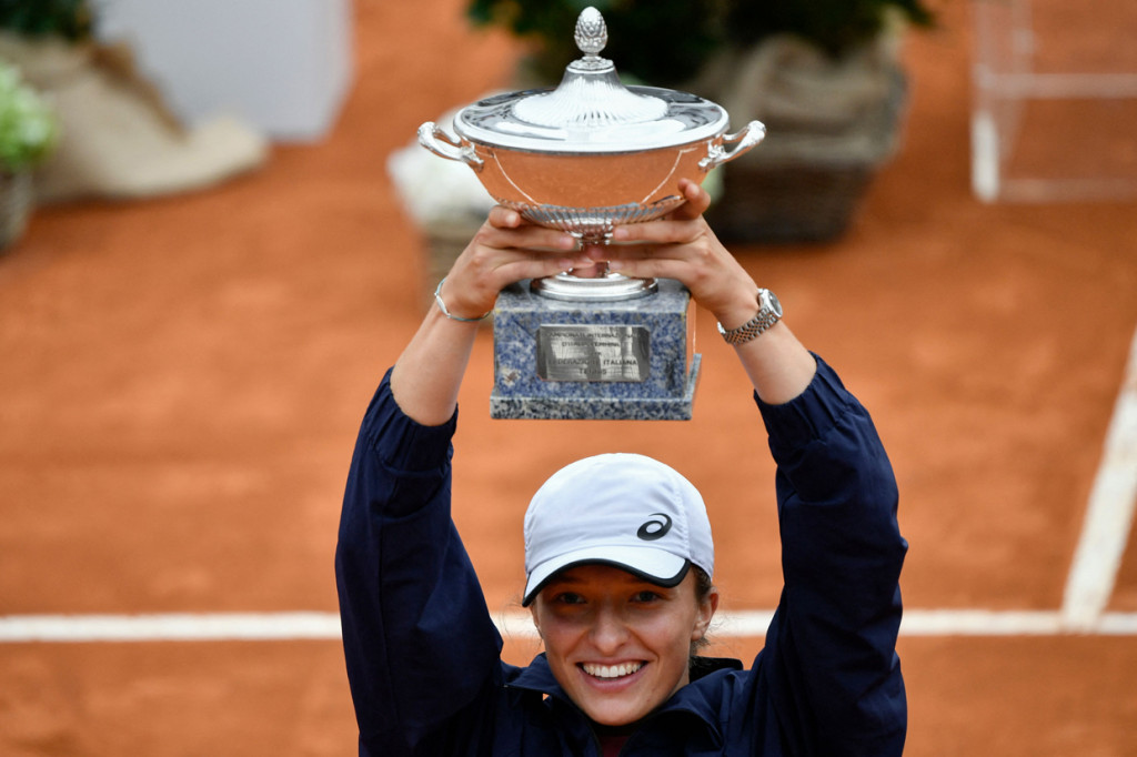 Petenis Polandia Iga Swiatek mengangkat piala kemenangannya setelah berhasil mengalahkan petenis Republik Ceko  Karolina Pliskova di babak final Turnamen Tenis Italian Open, di Foro Italico, Roma, Italia, Minggu, 16 Mei 2021.