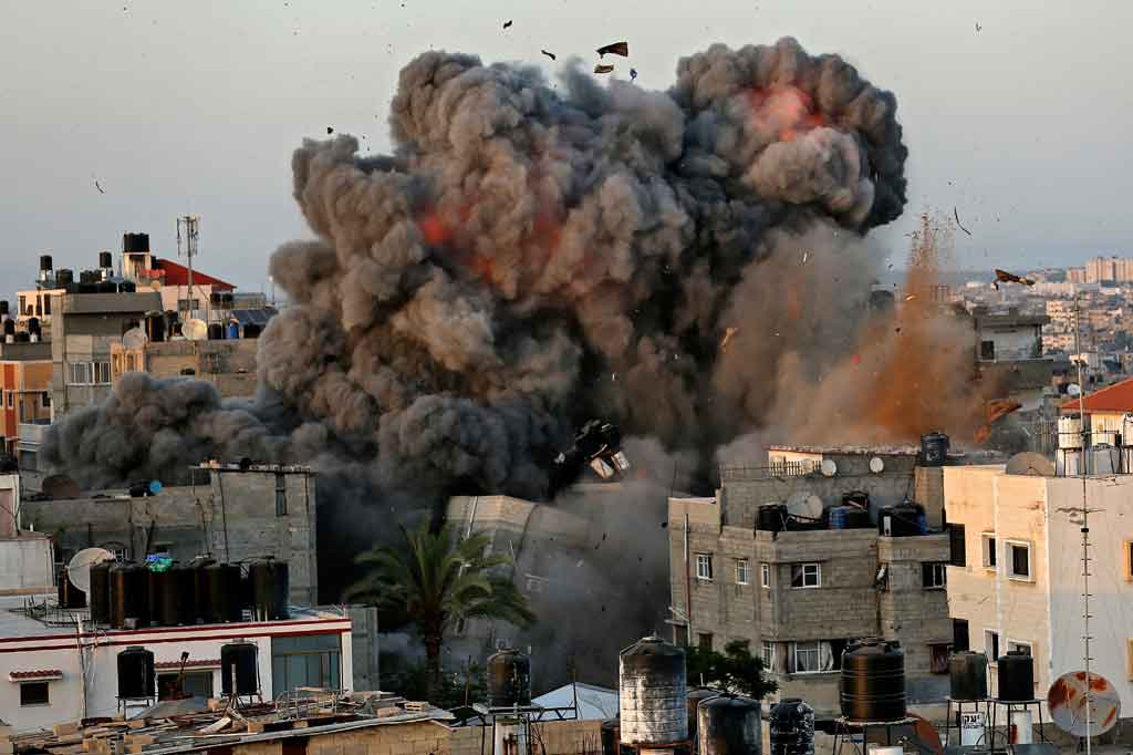 Bola api membubung ke angkasa dari sebuah bangunan di distrik pemukiman Rimal Kota Gaza pada 16 Mei 2021, selama pemboman besar-besaran Israel di daerah kantong yang dikuasai Hamas tersebut.