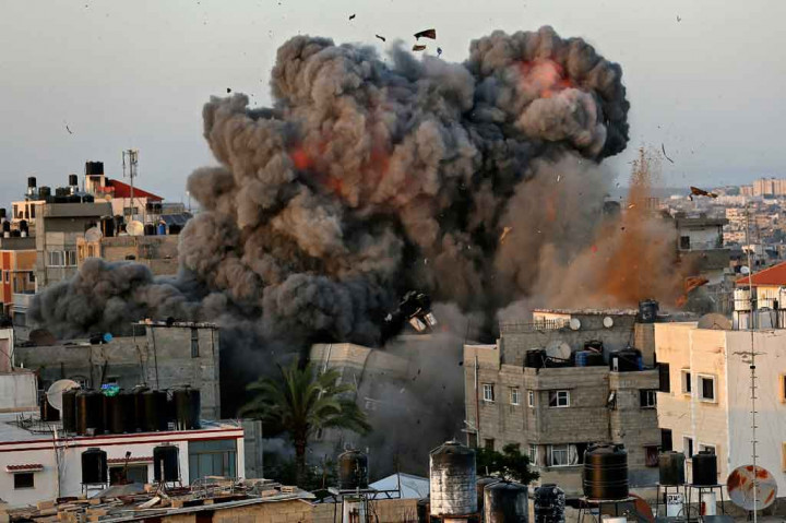 Bola api membubung ke angkasa dari sebuah bangunan di distrik pemukiman Rimal Kota Gaza pada 16 Mei 2021, selama pemboman besar-besaran Israel di daerah kantong yang dikuasai Hamas tersebut.