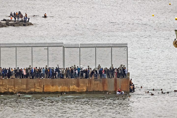 Migran Maroko berkumpul di pagar perbatasan di kota utara Fnideq dalam upaya untuk melintasi perbatasan dari Maroko ke daerah kantong Ceuta di Afrika Utara Spanyol.