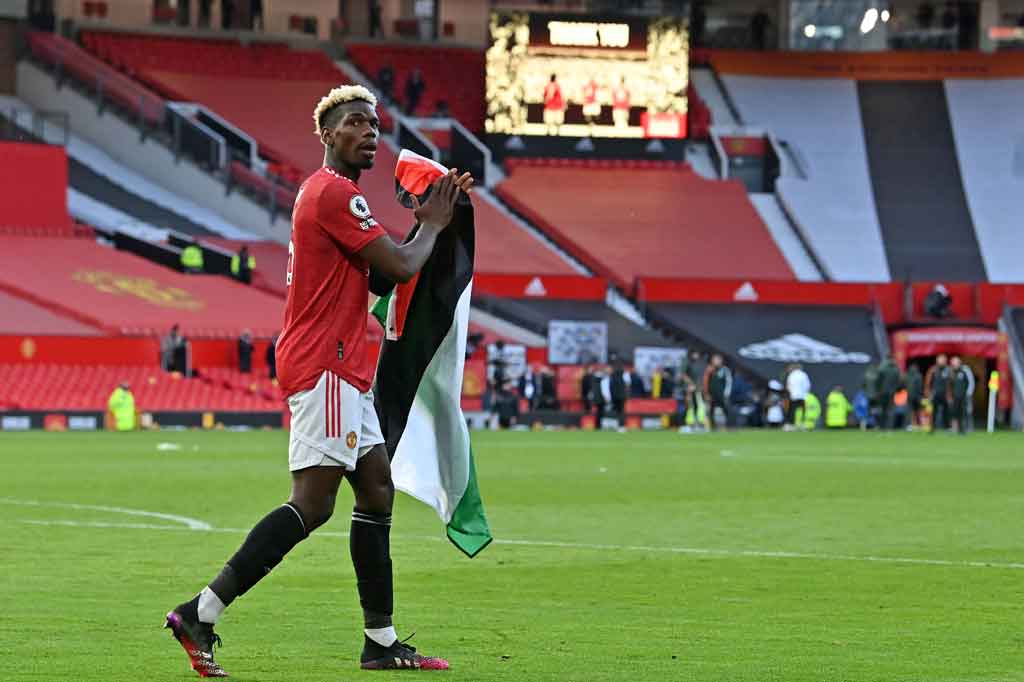 
Di depan sekitar 10 ribu penggemar yang hadir di Old Trafford setelah pelonggaran akibat pandemi covid-19, Pogba membentangkan bendera Palestina tinggi-tinggi. Aksinya itu kemudian diikuti pemain muda Diallo. Keduanya kemudian berkeliling stadion dengan membentangkan bendera Palestina.