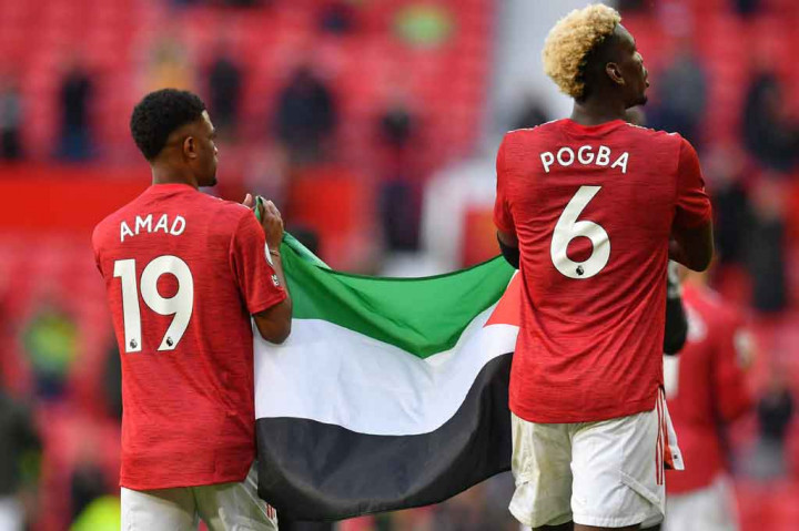 Duo Manchester United Paul Pogba dan Amad Diallo membentangkan bendera Palestina di Stadion Old Trafford usai laga Manchester United melawan Fulham, Rabu, 19 Mei 2021 dini hari WIB. Hal itu sebagai bentuk dukungan untuk Palestina yang tengah dibombardir oleh Israel.